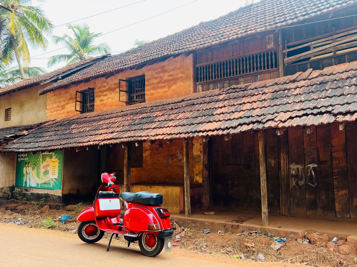Scooter parked outside an old tiled house near Honnavar
