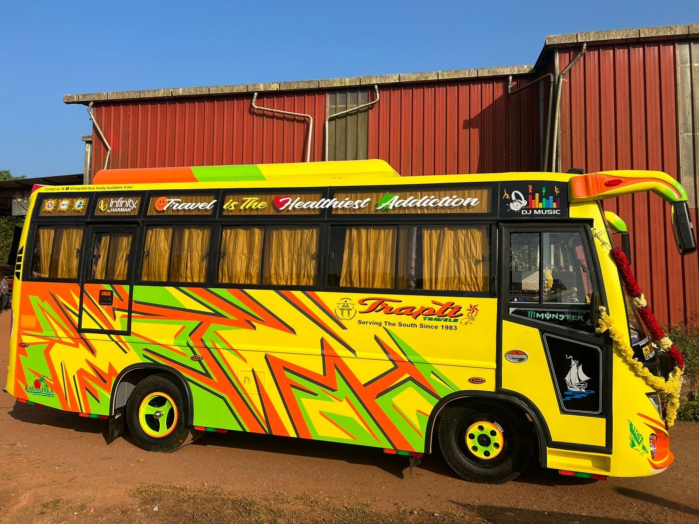Full side view of a Trapti Travels mini bus in its hand-painted livery