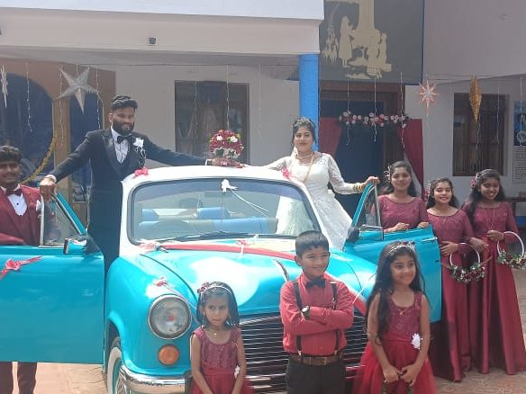 Wedding party with the open-top Ambassador at the church